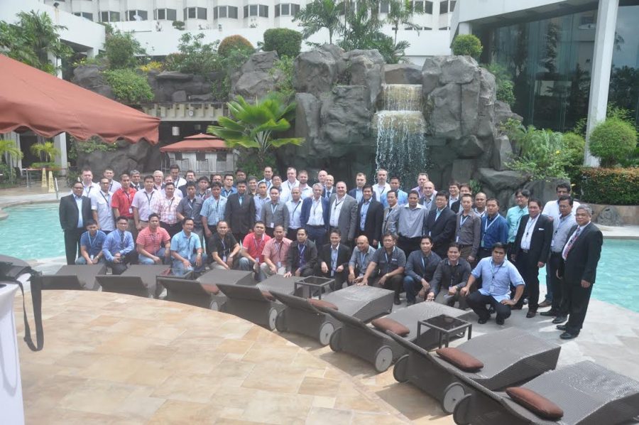 Large group photo in front of a pool
