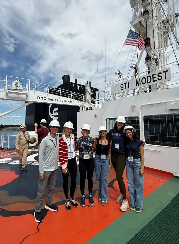 Scorpio interns standing with hard hats onboard a tanker vessel.