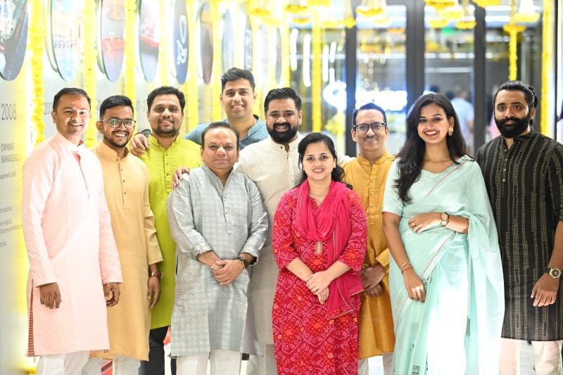 Group standing in front of yellow background.