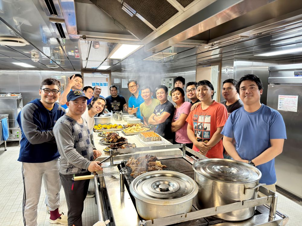 Tanker crew in the galley around a fresh meal.