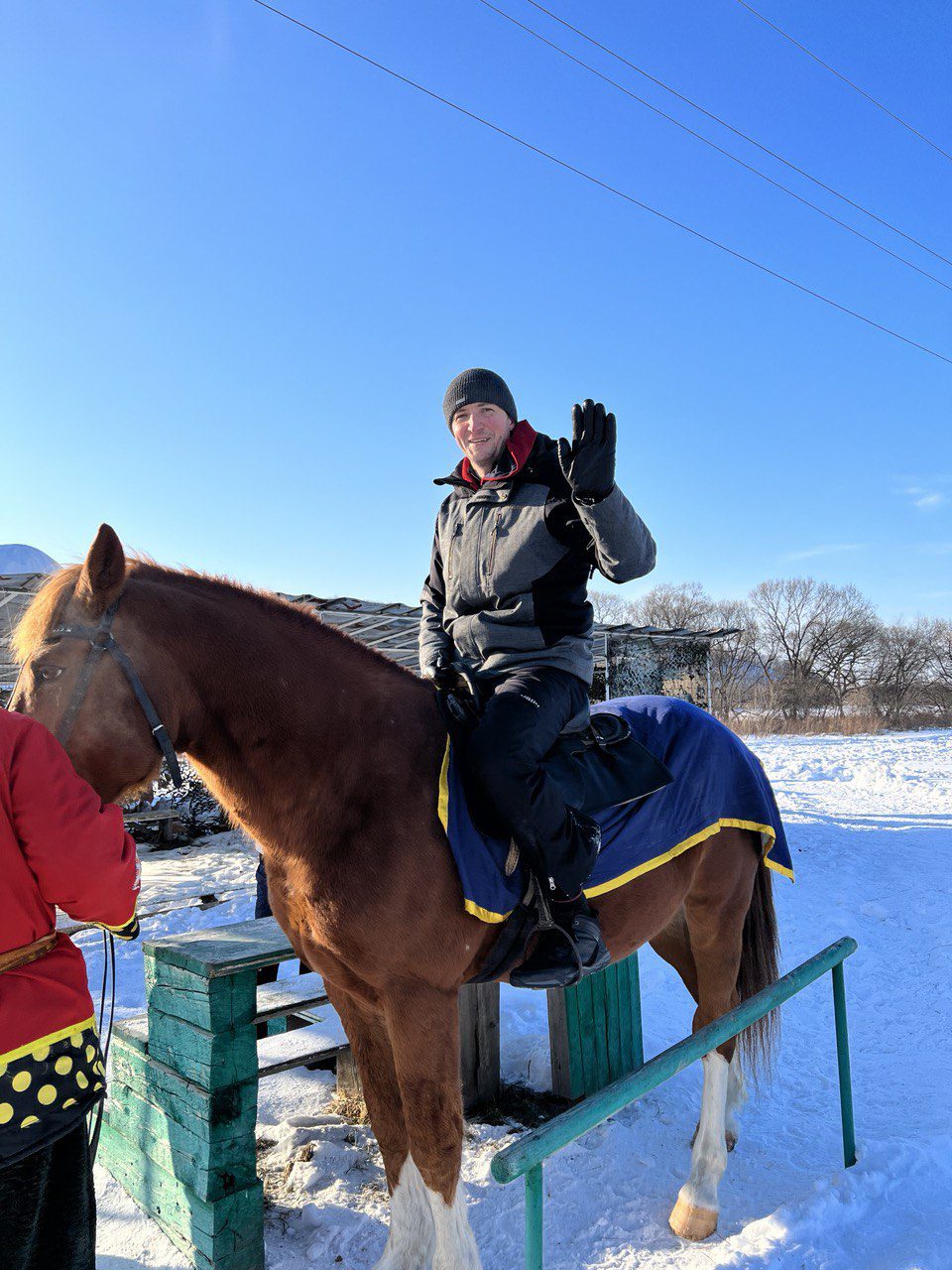 Man on a horse waving, with snow on the ground