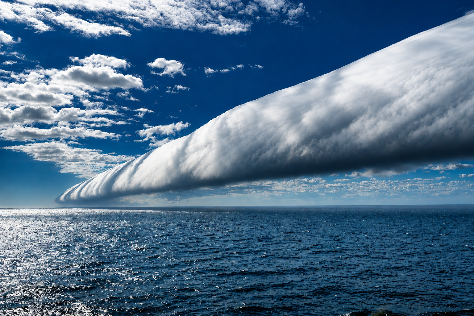 Cold front of clouds in a line perpendicular to the sea.