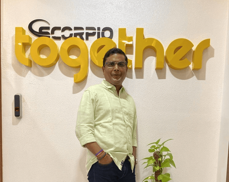 Yatin posing in front of Scorpio Together wall in Mumbai office.